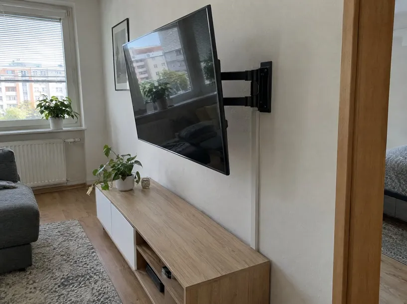 Televize zavěšená na výsuvném držáku v obýváku
